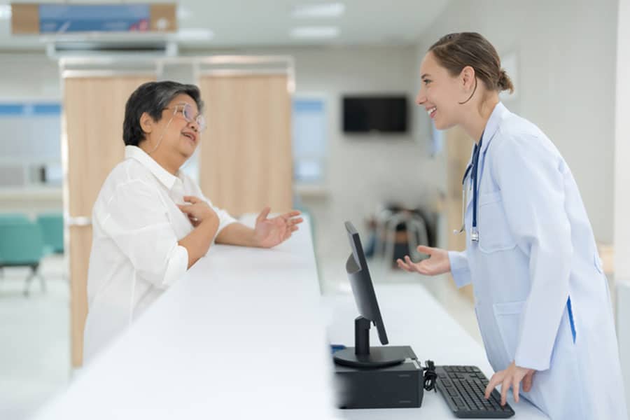 insurance-carriers Woman talking to front desk in medical office